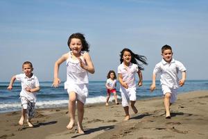 happy child group playing  on beach photo