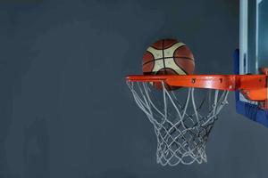 pelota de baloncesto y red sobre fondo gris foto