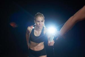 athletic runners passing baton in relay race photo