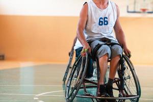 Close up photo of wheelchairs and handicapped war veterans playing basketball on the court