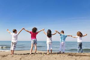 happy child group playing  on beach photo