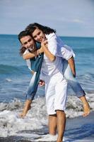 feliz pareja joven divertirse en la hermosa playa foto