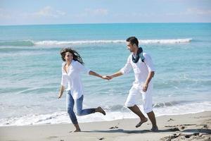 feliz pareja joven divertirse en la hermosa playa foto