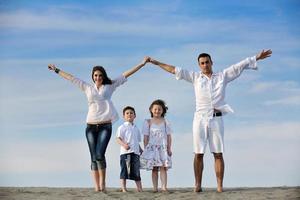 family on beach showing home sign photo