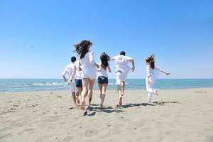 grupo de jóvenes felices divertirse en la playa foto