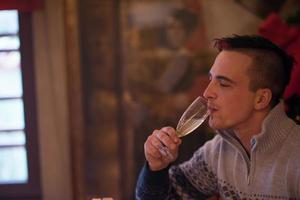 Happy young man with a glass of champagne photo