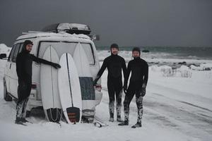 surfistas árticos en traje de neopreno después de surfear en minivan foto