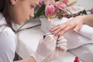 manos de mujer recibiendo una manicura foto