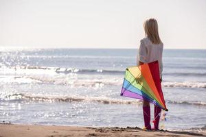 Young Woman with kite at beach on autumn day photo