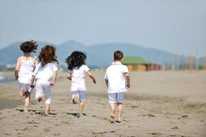 Grupo de niños felices jugando en la playa foto