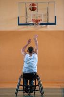 a war invalid in a wheelchair trains with a ball at a basketball club in training with professional sports equipment for the disabled. the concept of sport for people with disabilities photo