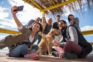 Group of friends having fun on autumn day at beach photo