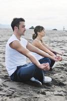 pareja yoga playa foto