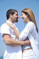 feliz pareja joven divertirse en la playa foto