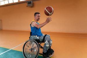 Disabled War veterans mixed race and age basketball teams in wheelchairs playing a training match in a sports gym hall. Handicapped people rehabilitation and inclusion concept photo