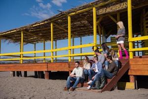 grupo de amigos divirtiéndose el día de otoño en la playa foto