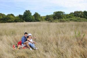 happy couple enjoying countryside picnic in long grass photo