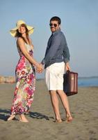 pareja en la playa con bolsa de viaje foto