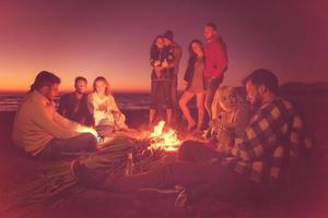 Friends having fun at beach on autumn day photo