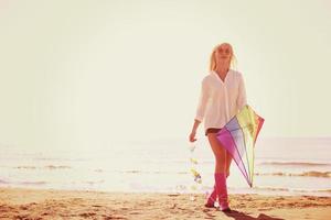 Young Woman with kite at beach on autumn day photo