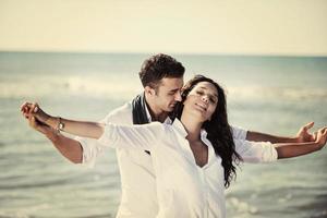 feliz pareja joven divertirse en la hermosa playa foto