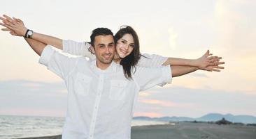 happy young couple have fun on beach photo