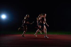 corredores atléticos que pasan la batuta en la carrera de relevos foto