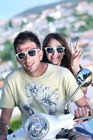 retrato de feliz pareja de amor joven en scooter disfrutando del verano foto