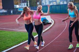 grupo de mujeres atletas corriendo en la pista de carreras de atletismo foto
