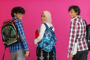 A group of Arab teenagers, a student team walking forward into the future and back to school the concept of a pink background. The concept of successful education for young people. Selective focus photo