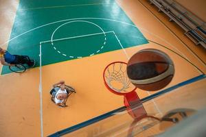 Remolque la foto de un veterano de guerra jugando al baloncesto en un estadio deportivo moderno. el concepto de deporte para personas con discapacidad