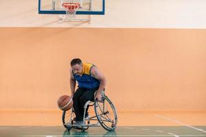 Disabled War veterans mixed race and age basketball teams in wheelchairs playing a training match in a sports gym hall. Handicapped people rehabilitation and inclusion concept photo