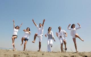 grupo de jóvenes felices divertirse en la playa foto