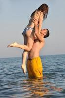 happy young couple have fun on beach photo