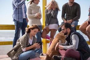 grupo de amigos divirtiéndose el día de otoño en la playa foto