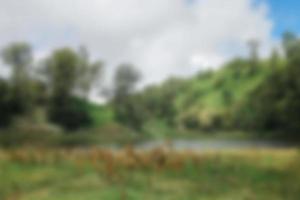 Blurred view of lake ranu kumbolo, semeru mountain. bokeh background in summer, green nature concept photo