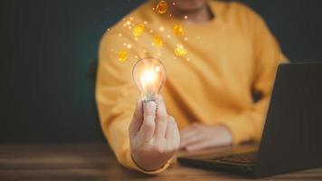 Freelancer touching a bright light bulb. Ideas for making money from ideas and introducing new ideas. inspiration for work and innovation in new beginnings. photo