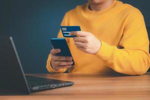 A man using credit card for purchasing and shopping online on mobile phone. Mobile payment with wallet app technology. Digital money transfer, banking and e commerce concept. photo