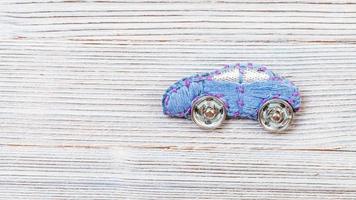 car brooch embroidered by silk threads on gray photo