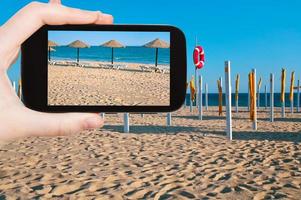 tourist taking photo of straw beach umbrellas