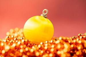 Yellow bauble for a Christmas tree on a red background. Christmas banner with place for text. photo