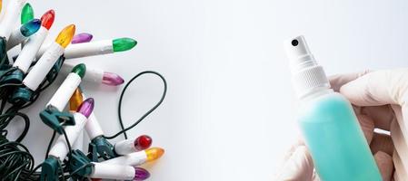 A hand in a protective glove holding a container with an antibacterial liquid on a white background. The concept of maintaining hygiene during a pandemic. photo