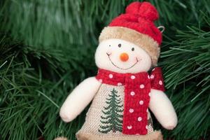 Smiling Christmas snowman handmade in a hat and scarf. Christmas decoration made of fabric. photo