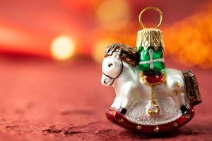 Christmas tree decoration. Decorative horse. Christmas banner on a red background. photo