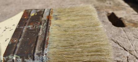 old brush with shabby bristles on long wood photo