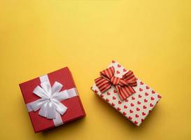 Red and white gift box with on yellow background,flat lay photo