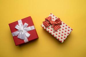 Red and white gift box with on yellow background,flat lay photo