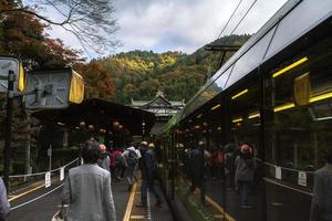 Kurama, Kyoto Prefecture, Kansai, Japan - November 21, 2019 - Tourists getting out of train at Kurama Station, the last station of Eizan Railway Kurama Line photo