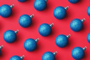 Blue Christmas ball bauble pattern minimal flatlay on red background top view photo