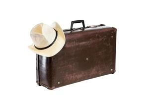 Vieja maleta de fibra marrón con sombrero aislado sobre fondo blanco. foto